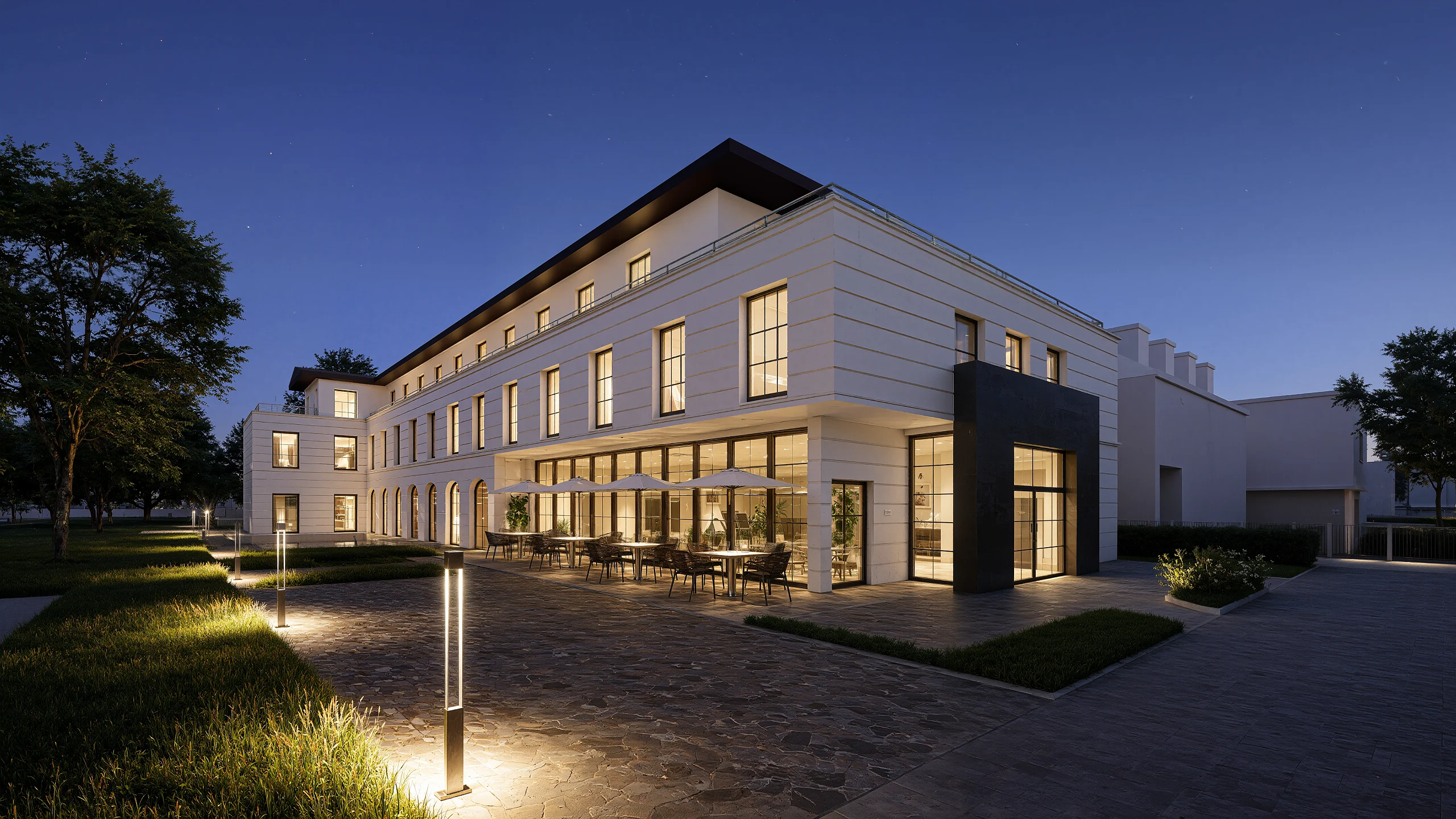 Courtyard side of the Hamburg hotel at night, lit ground floor and terrace